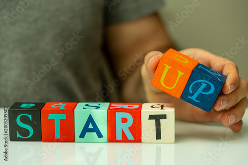 Hand places wooden blocks s...