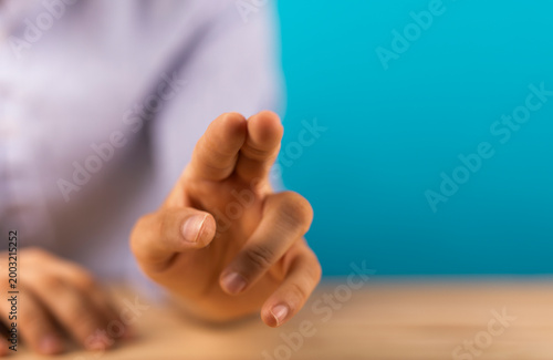 Close-up of a hand with a gesture of pointing or touching a screen with blurred background.