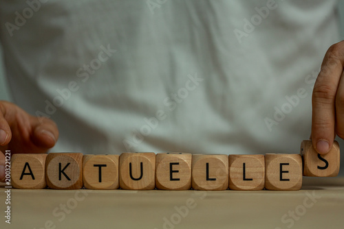 Photography Hands arrange wooden blocks spelling current news and information updates