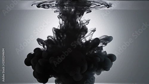 Ink swirling in water creating captivating black cloud patterns  