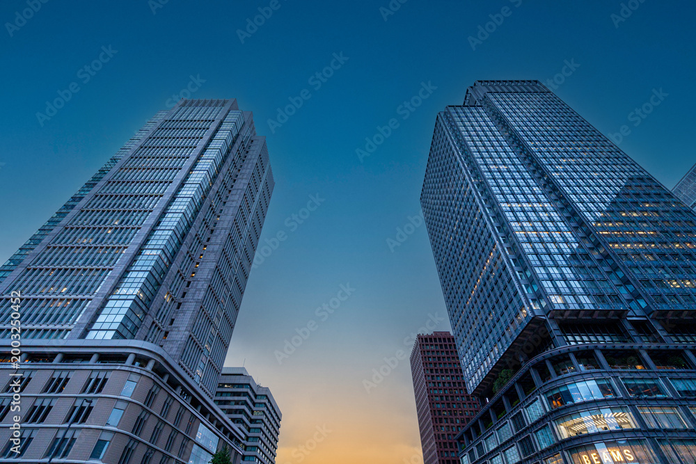 Naklejka premium 夕暮れの空にそびえ立つ高層ビル群