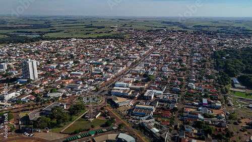 Aerial view of Assis Chateaubriand, Parana, showing the urban area, vegetation, and highway on a sunny day.