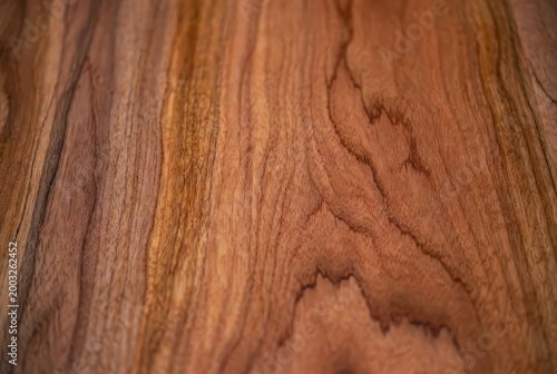 Rich, warm brown wood grain texture with abstract, organic swirling patterns and natural lines