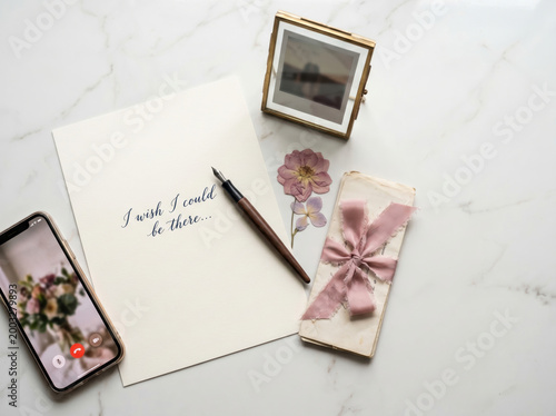 Flat lay of a handwritten note saying i wish i could be there with a fountain pen, a mobile phone on a video call, pressed flowers, and a tied stack of letters on a marble surface