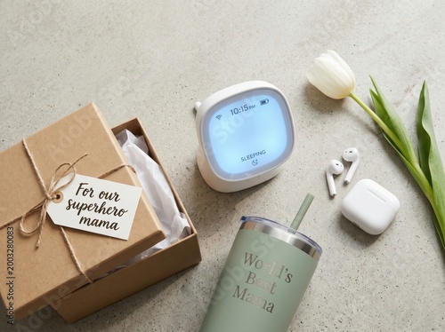 Gift set for mothers day with a personalized tumbler, baby monitor, and white tulips on a concrete background