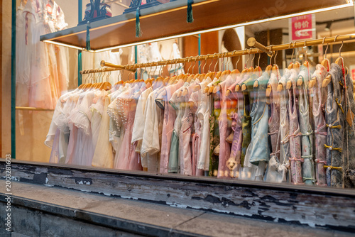 Fotografia Suzhou, China, 31 March 2026 ? Traditional Chinese Hanfu garments in pastel colors hang on golden racks in a boutique shop window display during spring