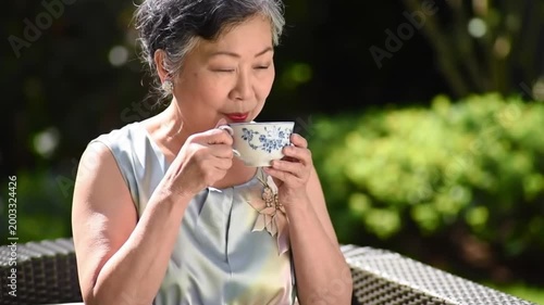 Senior woman enjoying tea outdoors.
