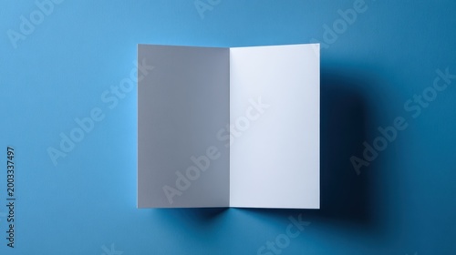 Blank white bifold brochure or greeting card mockup standing on a textured blue background