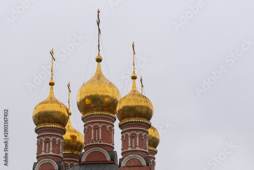 Golden domes sparkle against a cloudy sky. Faith and architectural beauty, the essence of cultural heritage and spirituality.