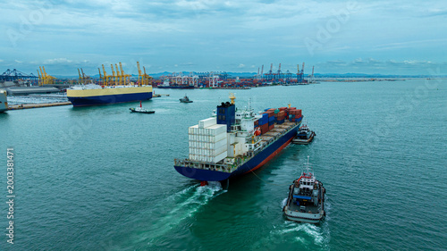 Tugboat Guiding A Massive Container Ship Into A Busy Industrial Port For Maritime Freight Delivery