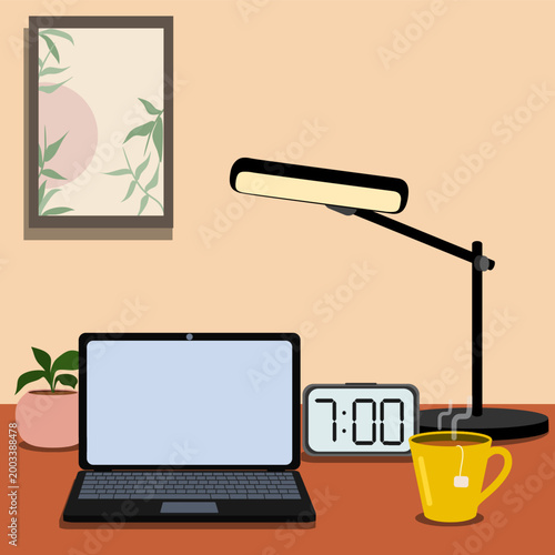 Workspace with laptop, desk lamp and tea cup with teabag on desk