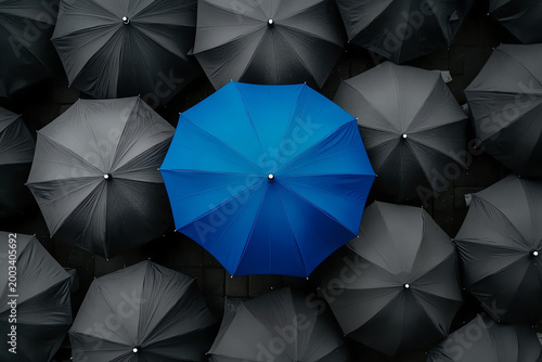 Blue Umbrella Standing Out Among Gray Umbrellas – Symbol of Innovation and Leadership