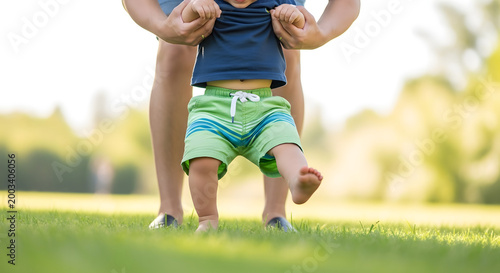 A parent helping a child wear shoes on the Global Day of Parents in a park.