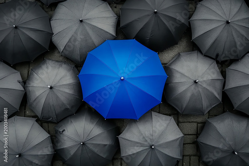 Blue Umbrella Standing Out Among Gray Umbrellas – Symbol of Innovation and Leadership
