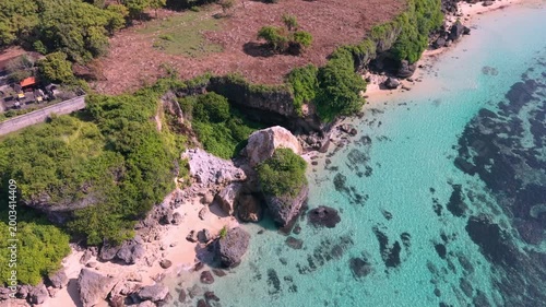 High Aerial View of Geger Beach Bali with Rocky Cliffs, Turquoise Lagoon, and Pristine White Sand