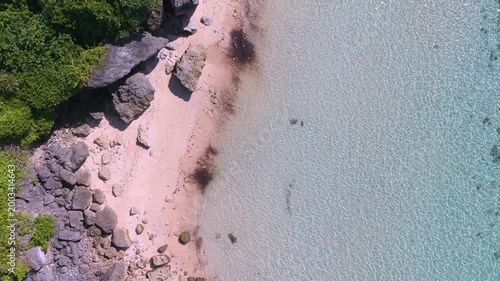 Aerial Top View of Geger Beach Bali Featuring Crystal Clear Turquoise Water, White Sand, and Rocky Shoreline
