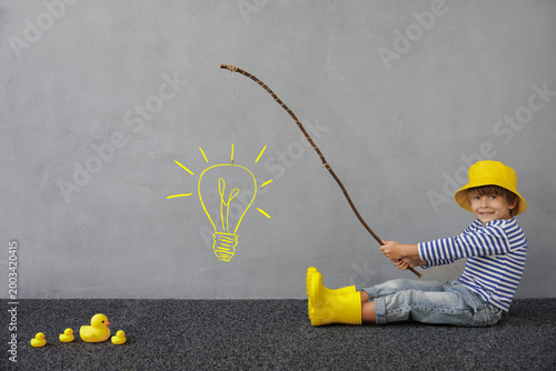 Idea! Happy child playing indoor. Kid enjoying a fishing trip. Little boy having fun at home