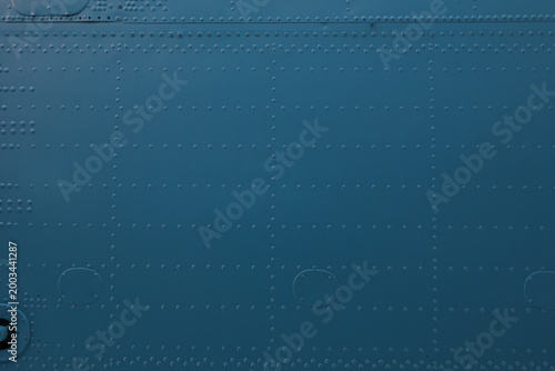 Smooth metal surface with rivets and circular cutouts