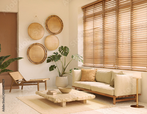 Minimalist Japandi living room interior with beige sofa, wooden blinds, and natural rattan wall decor in warm sunlight.