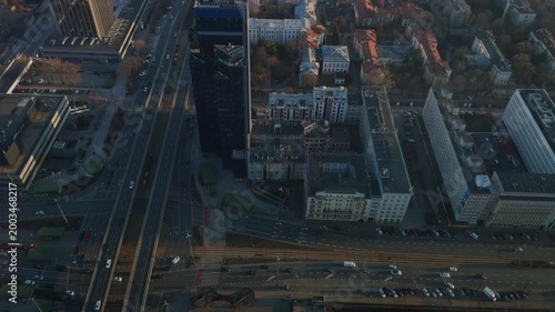Aerial view of a modern dark skyscraper in the center of a busy city
