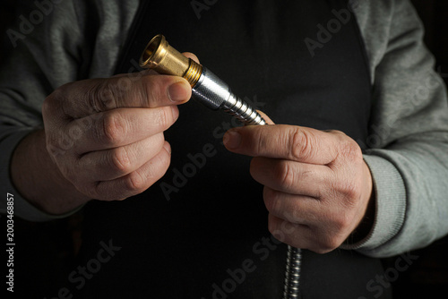 Φωτογραφία A person is holding a metal hose connector in both hands