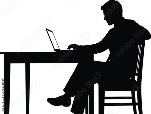 Silhouette of a person working on a laptop