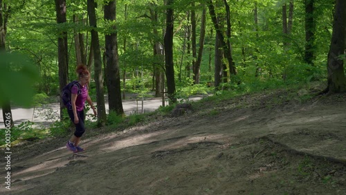 Woman hiking up forest slope
