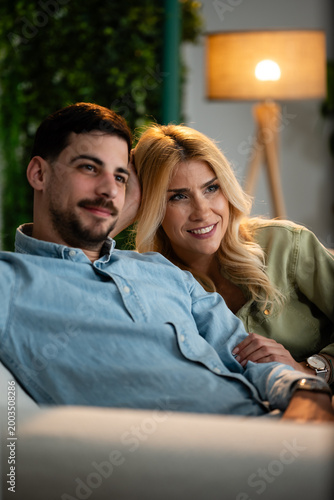 Foto Happy couple relaxing at home watching television