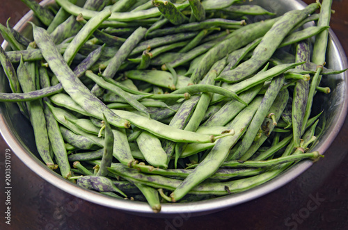 Fresh green string beans with purple stripes close-up. Raw, organic flat string beans. Raw vegetables from the garden.