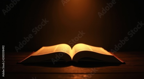 An open book sitting on a table with a light shining on it