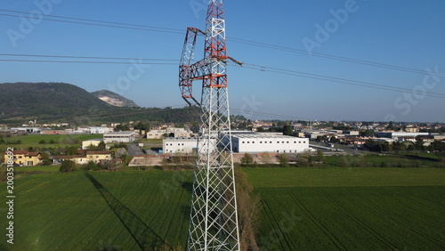 Tableau sur toile High-voltage electricity pylon in a rural landscape with industrial area