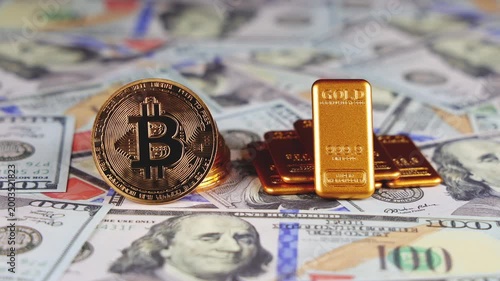 Des lingots d'or et des pièces de bitcoin posés sur des billets de banque en dollars. Concept de dollar vs or et bitcoin.