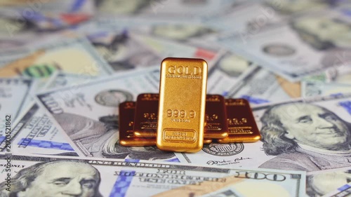 Gros plan sur des lingots d'or posées sur des billets en dollar. Concept de dollar vs or.