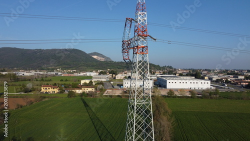 Foto High-voltage electricity pylon in a rural landscape with industrial area