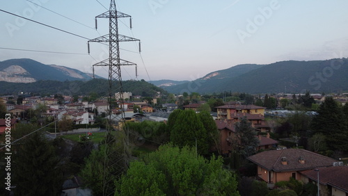 High-voltage electricity pylon in a rural landscape with industrial area