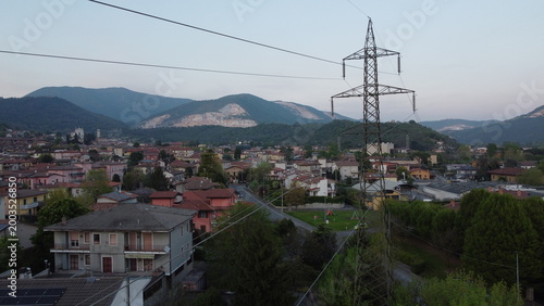High-voltage electricity pylon in a rural landscape with industrial area