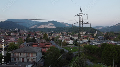 High-voltage electricity pylon in a rural landscape with industrial area