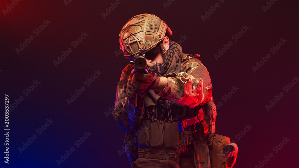 Naklejka premium Soldier holding position on blurred red and blue gradient background. Concept strength and readiness. 