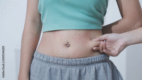 Overweight woman body with hands touching belly fat
