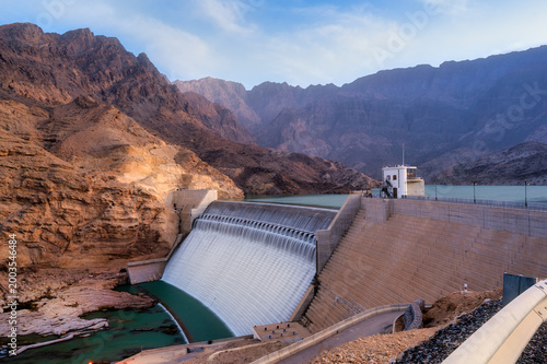 фотографія Wadi Dayqah Dam with mountain landscape in Oman at golden hour