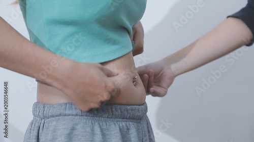 Overweight woman body with hands touching belly fat