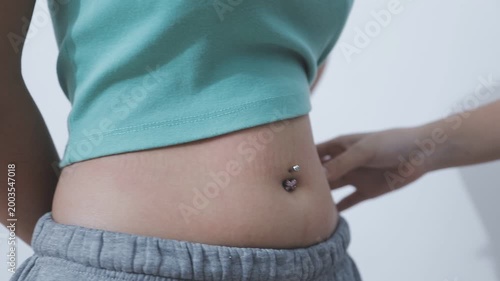 Overweight woman body with hands touching belly fat