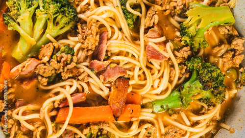 Foto Creamy noodles with minced beef, bacon and vegetables including broccoli, served in a bowl