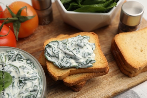 Fotografía Delicious toasts with creamed spinach served on table, closeup