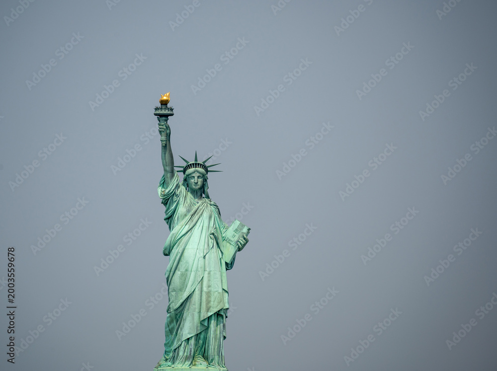 Fototapeta premium New york, usa august 16,2024. Statue of liberty on liberty island under an overcast sky, iconic symbol of freedom, democracy and welcome in the usa