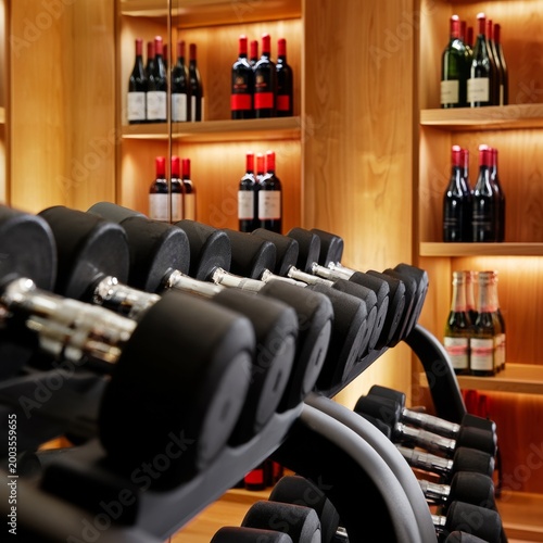 Weights in a Gym With Wine Bottles on Display in the Background at an Indoor ...
