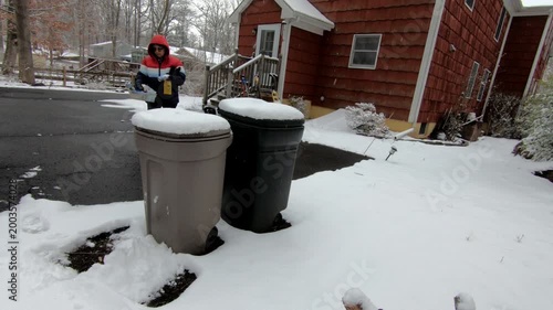 woman emptying the recycling trash in the backyard after the snow storm in February