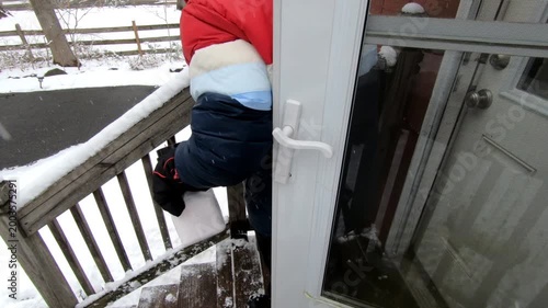 woman salting the stairs after shoveling the snow from the stairs after the snow storm in February