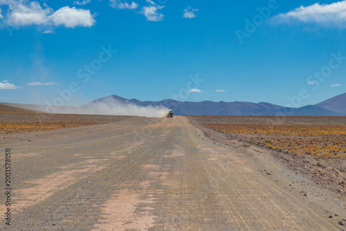 Heavy industrial truck driving on a dusty gravel road in the Puna de Atacama desert near Tolar Grande, Salta, Argentina. Logistic transportation