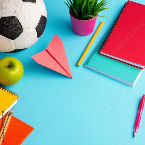 Colorful School Supplies and a Soccer Ball on a Blue Table With an Apple and ...